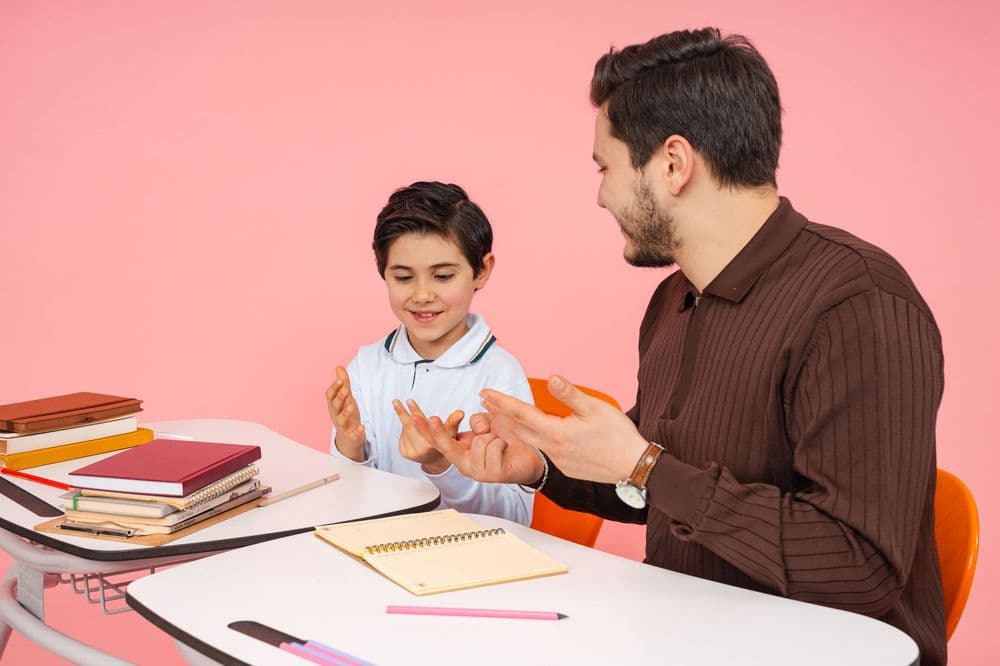 A male tutor and a smiling young student during a lesson
