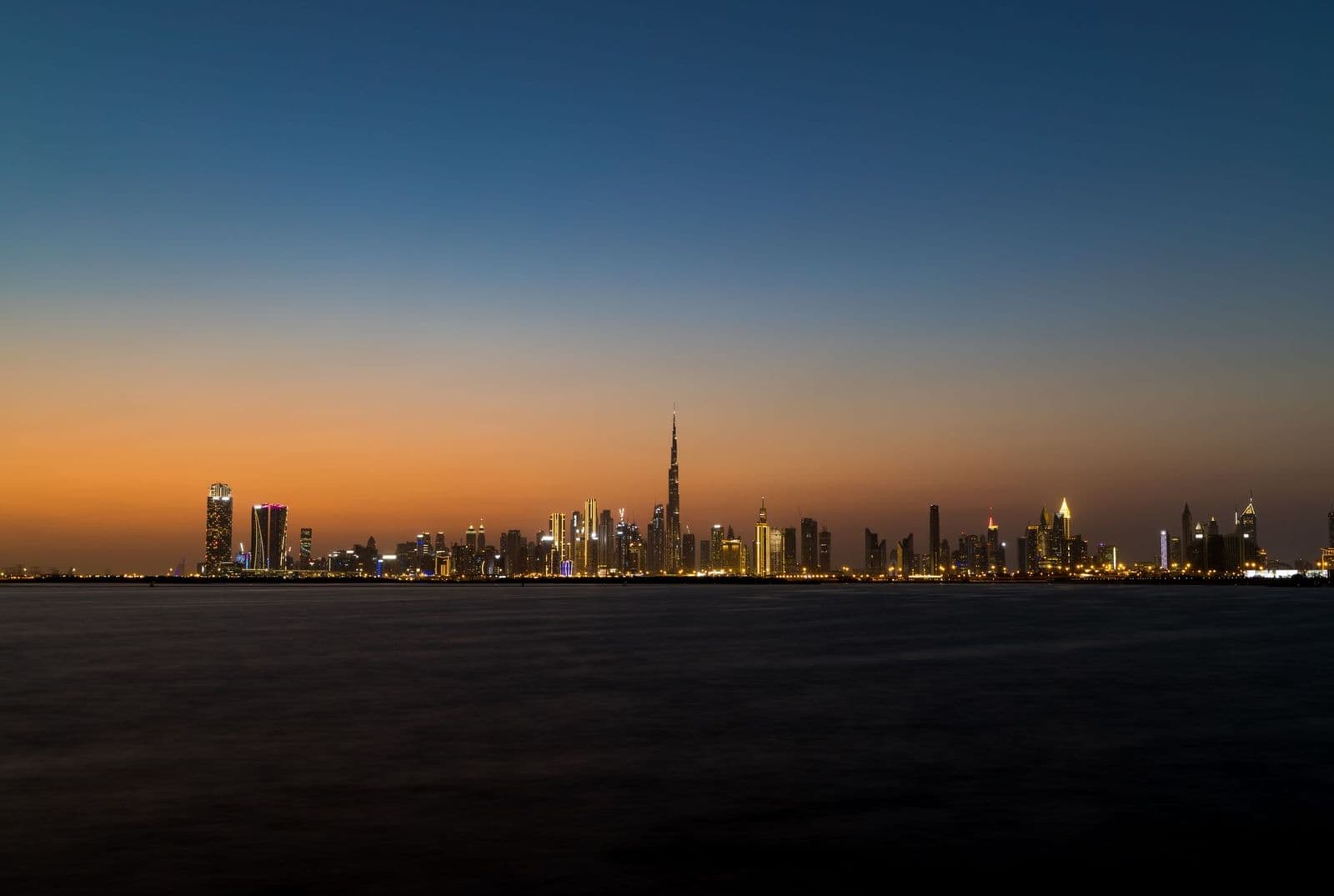The Dubai skyline at dusk seen across the water