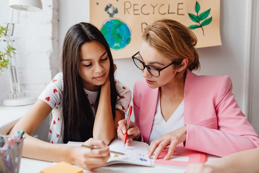 A tutor going through homework with a teenage student at home