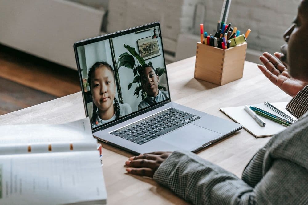 A teacher giving a lesson to two students over a video call